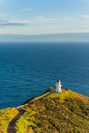 a lighthouse on top of a hill overlooking the ocean