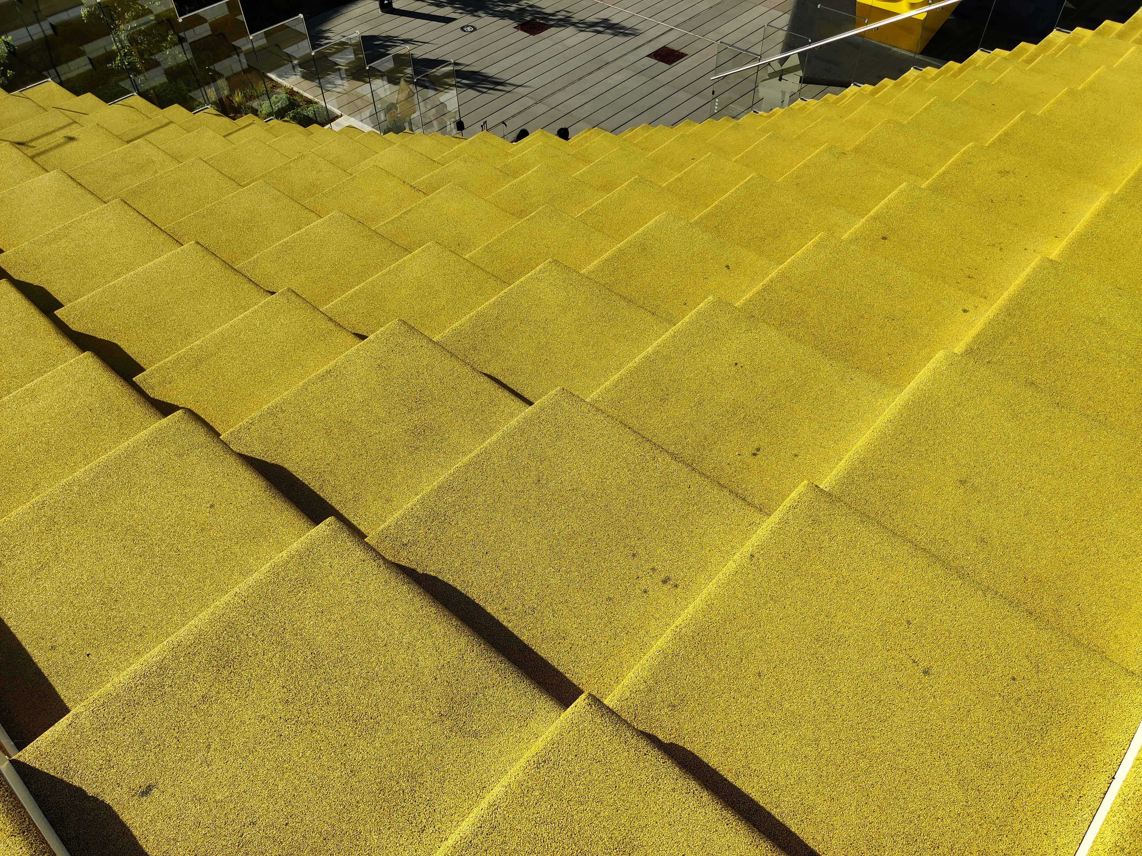 a close up of a yellow roof with a building in the background