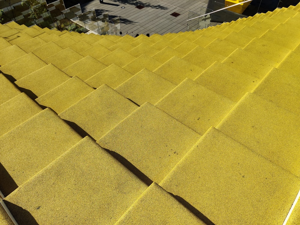 a close up of a yellow roof with a building in the background