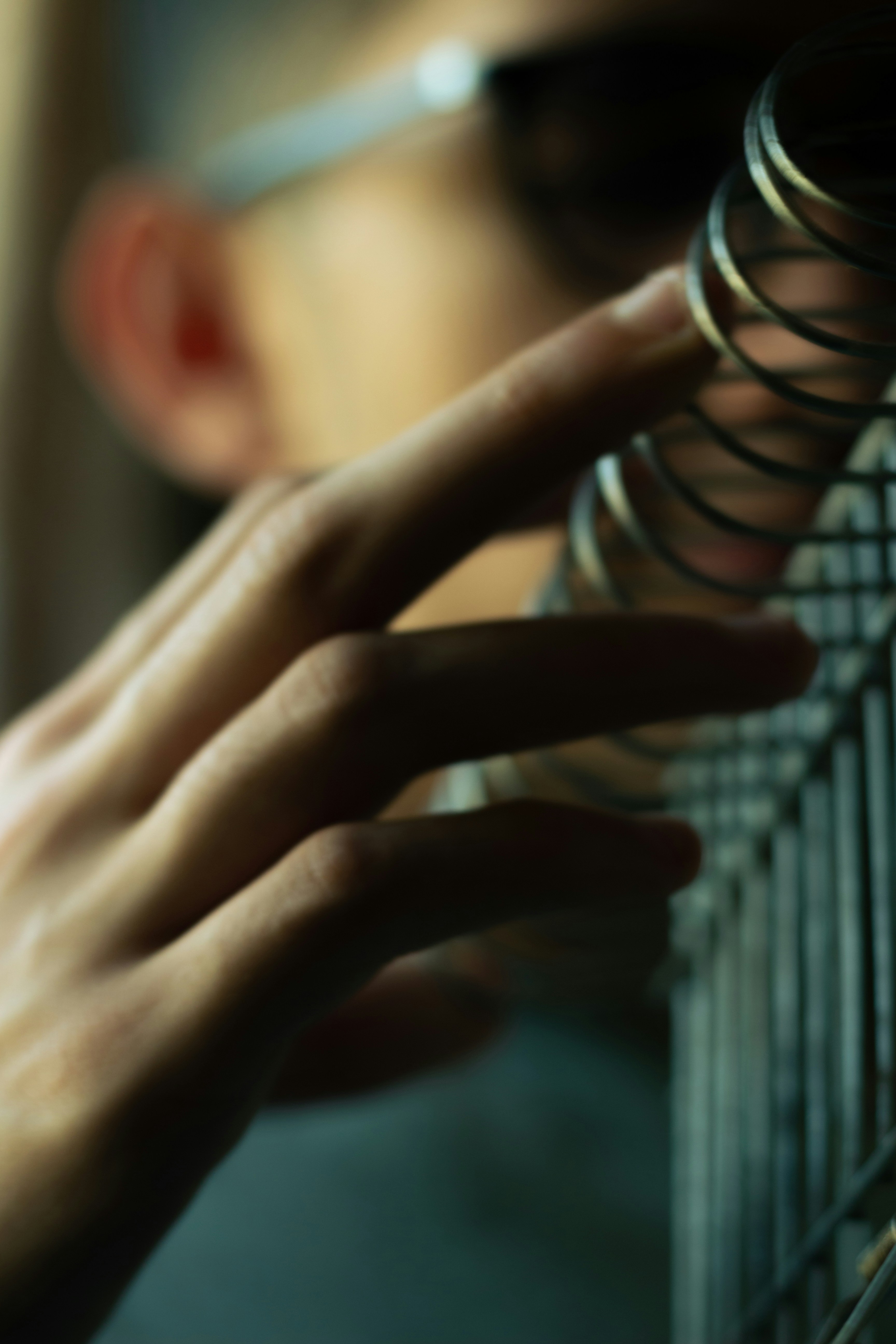una persona sta toccando una recinzione con la mano