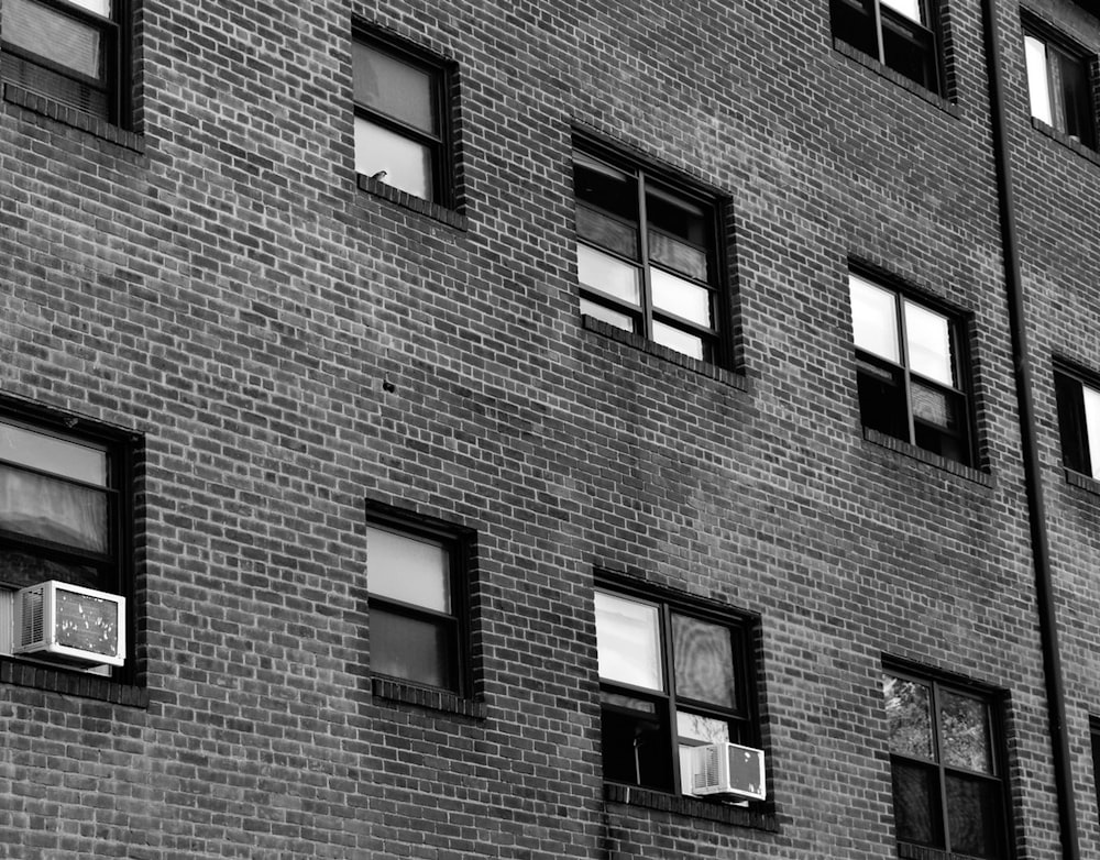 a black and white photo of windows on a brick building