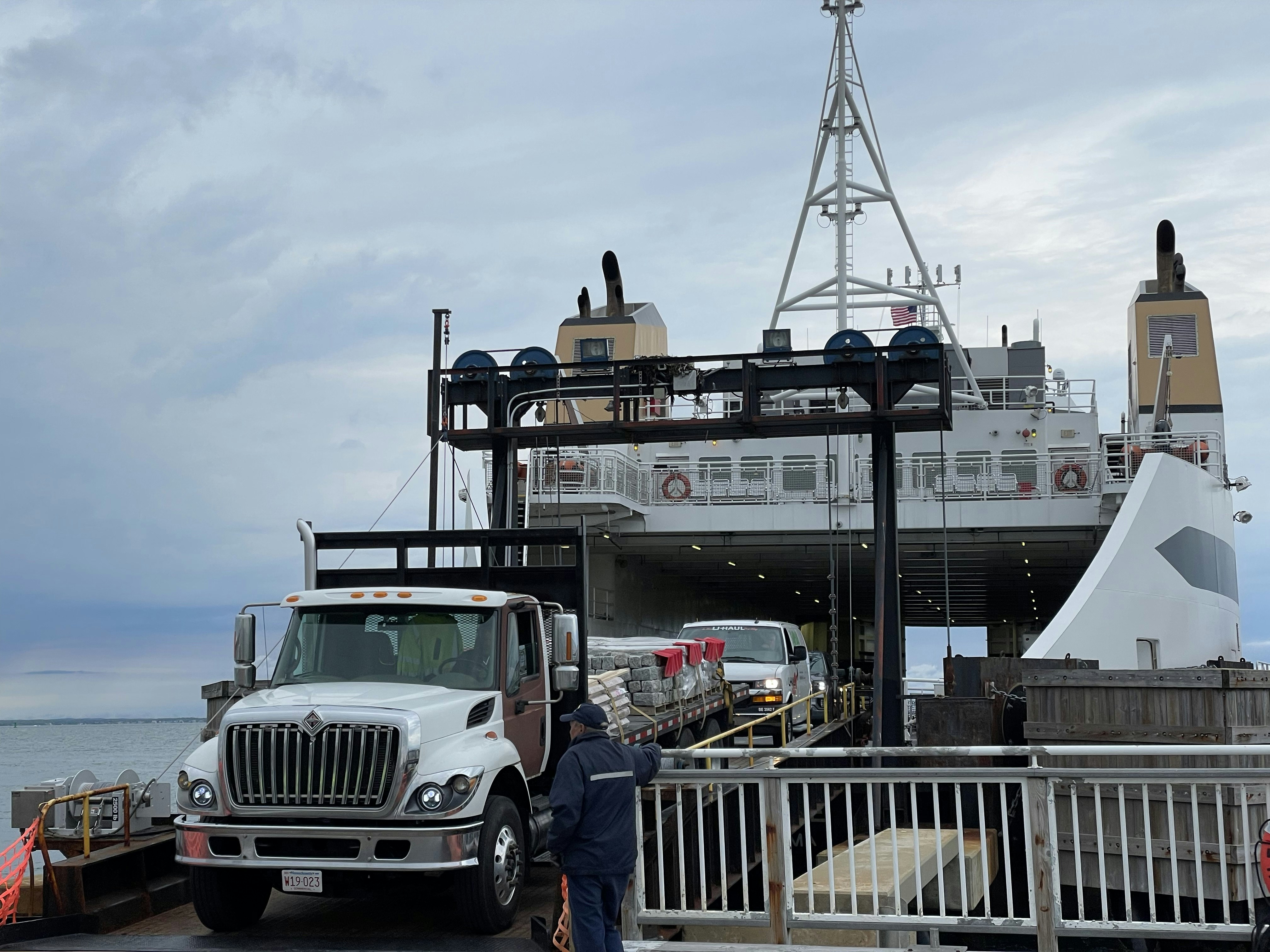 a man standing next to a truck on top of a pier