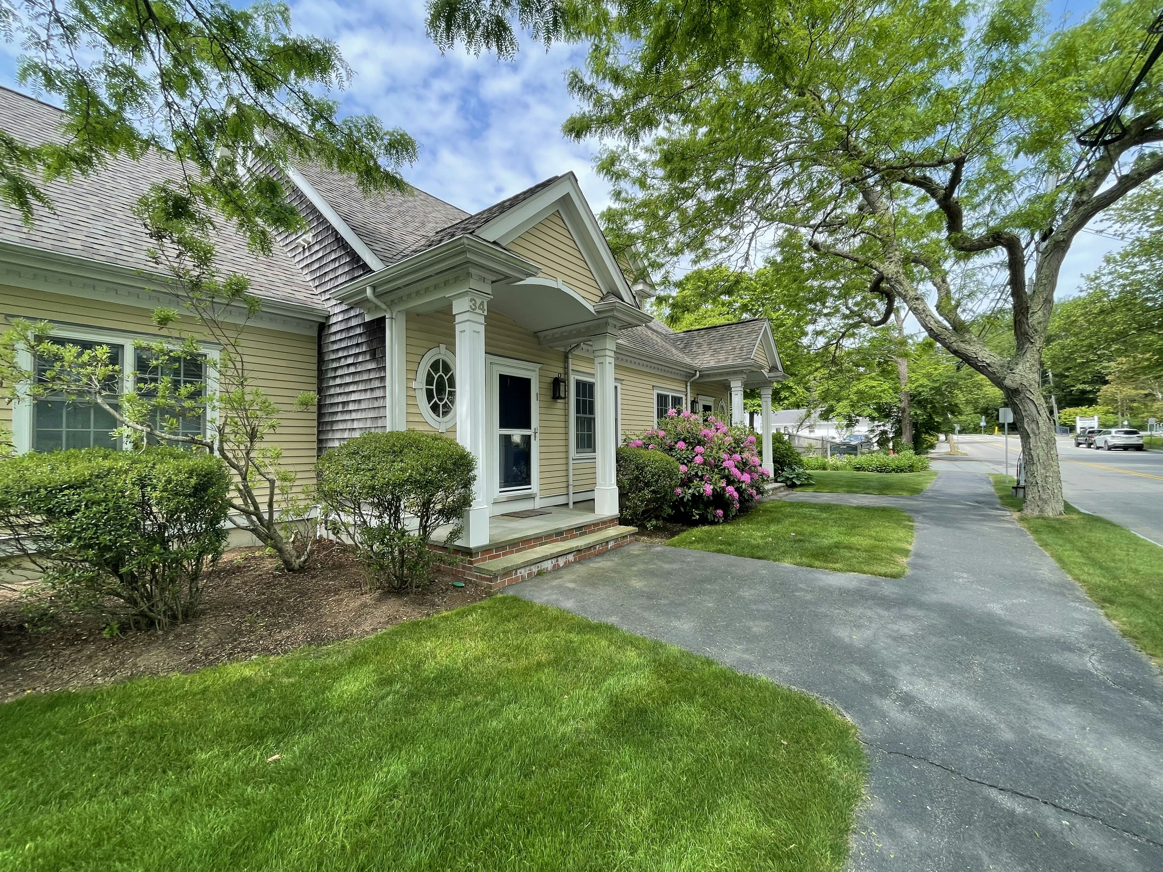 A charming suburban house with a white picket fence and blooming garden.