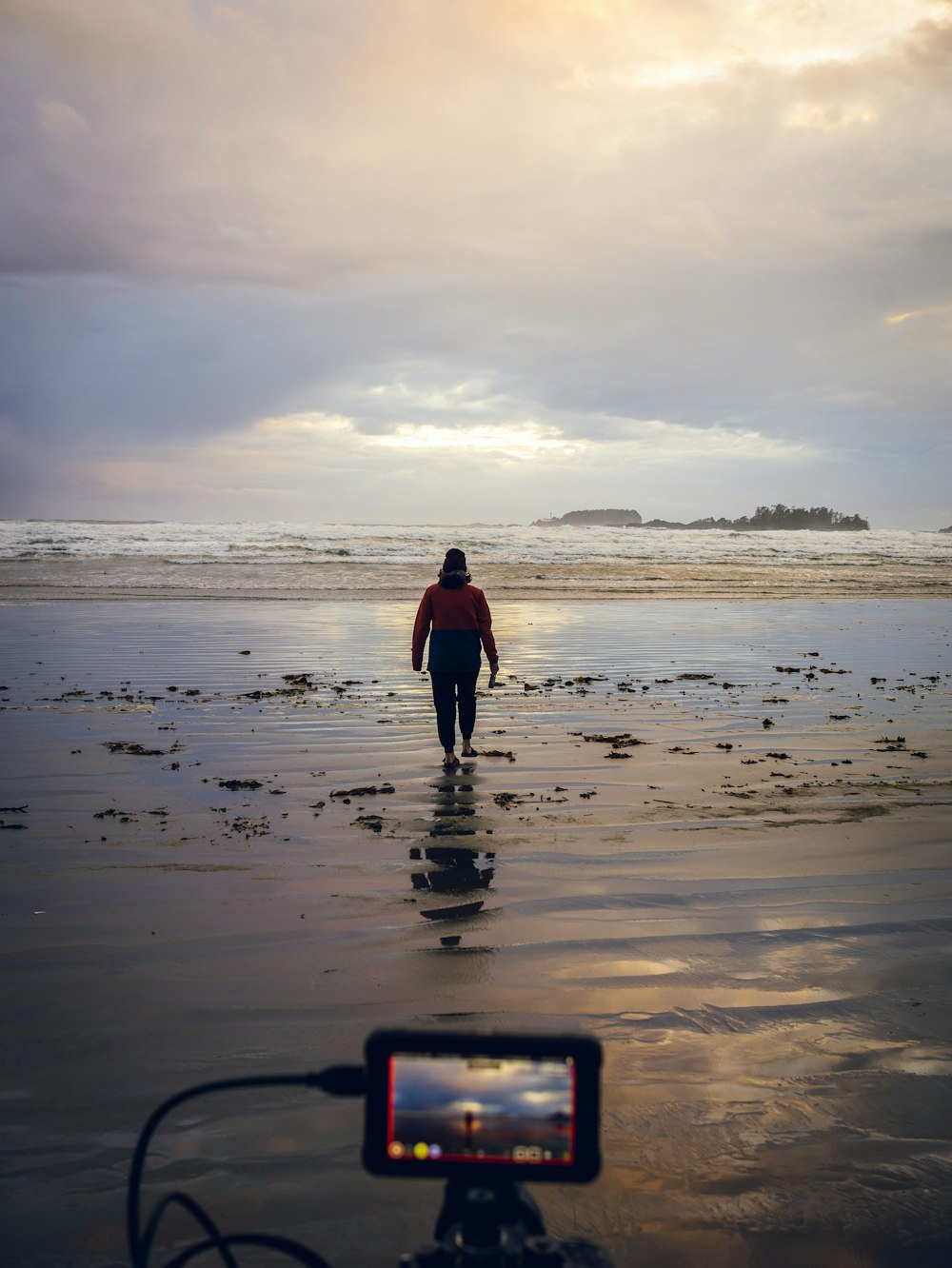 a person walking on a beach next to the ocean