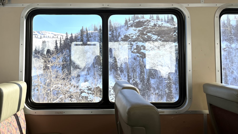a view of a snowy mountain out of a train window