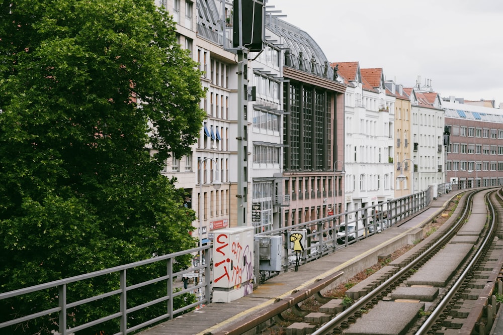 a train track running through a city next to tall buildings