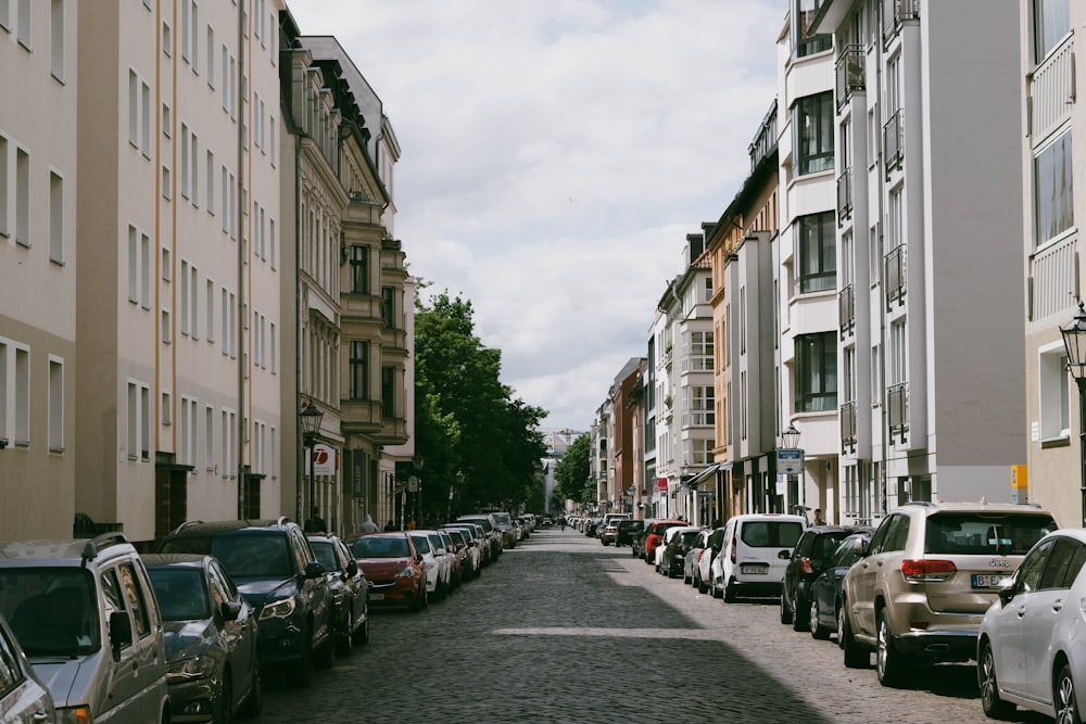 a street lined with parked cars next to tall buildings