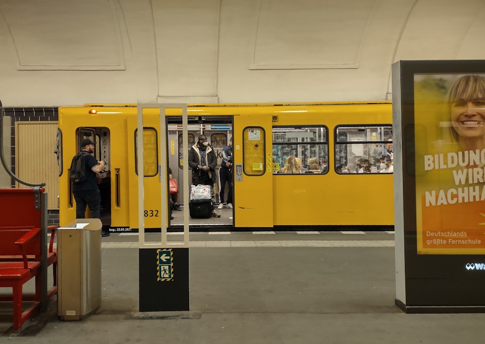 a yellow train with a poster on the side of it