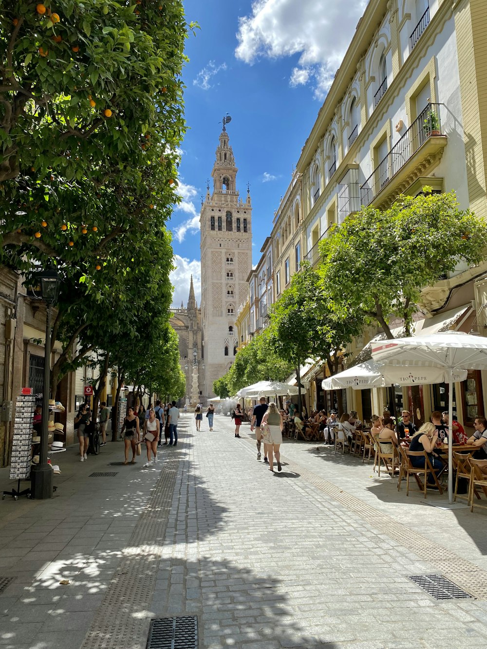 Eine Stadtstraße mit Tischen und Sonnenschirmen