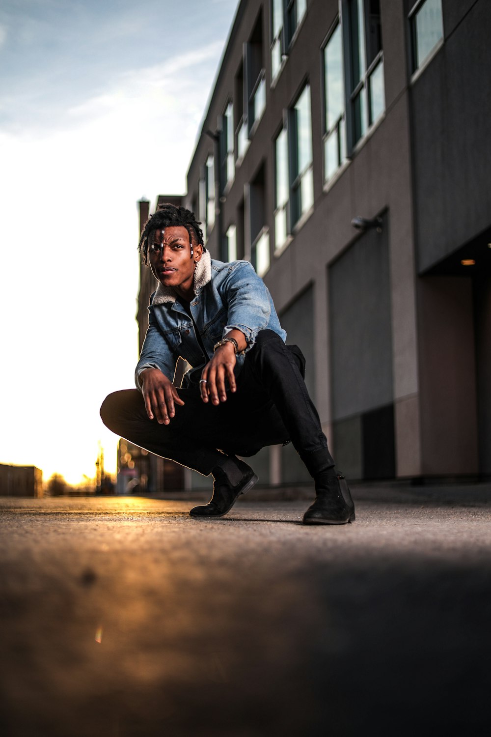 a man kneeling down on the ground with a skateboard