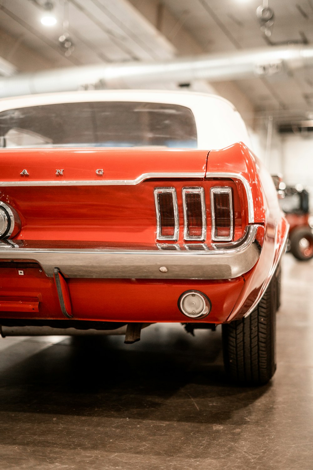 a red car parked in a garage next to other cars