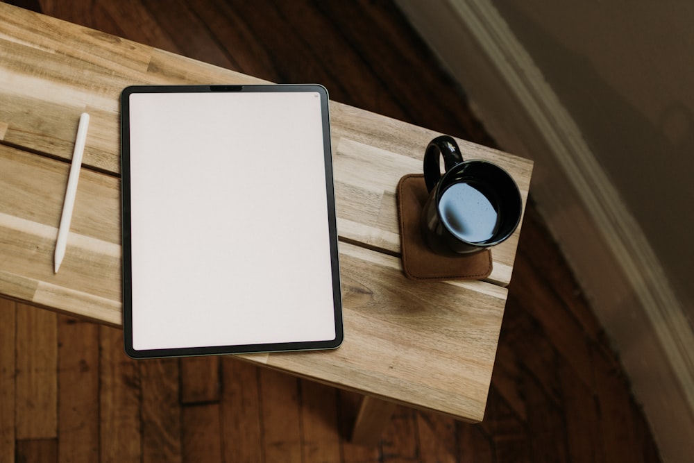 a tablet computer sitting on top of a wooden table