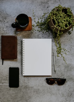 A serene workspace with a journal, a cup of coffee, and a plant, symbolizing daily reflection and growth.