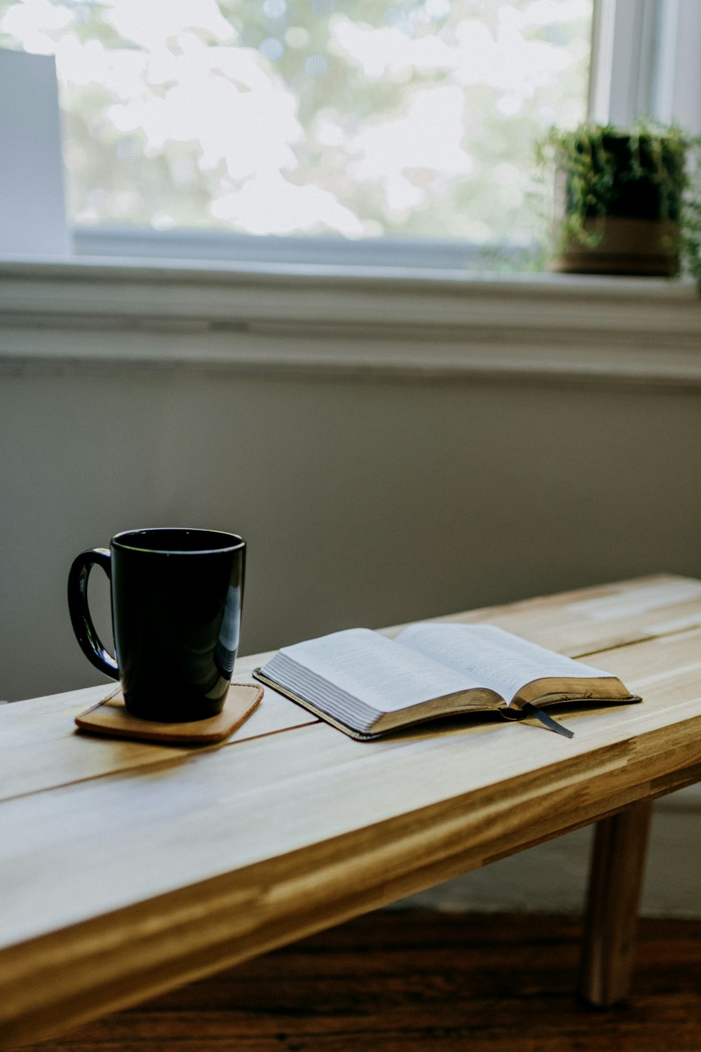 a book and a cup on a wooden table