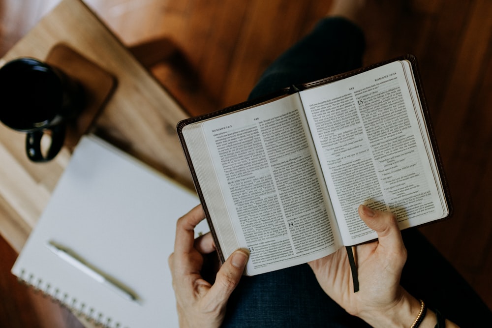 a person holding an open book in their hands