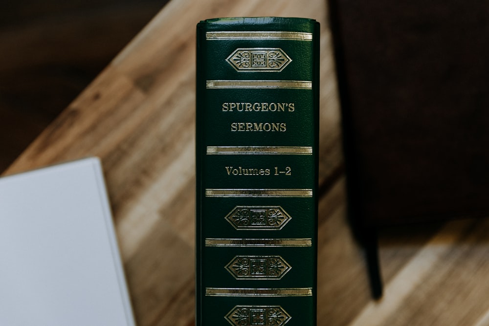 a green book sitting on top of a wooden table