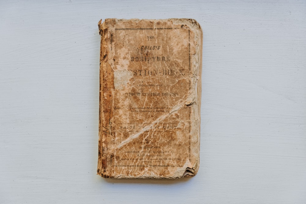 an old book sitting on top of a white wall