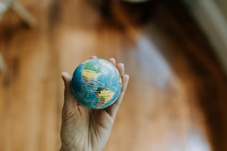 a person holding a small globe in their hand