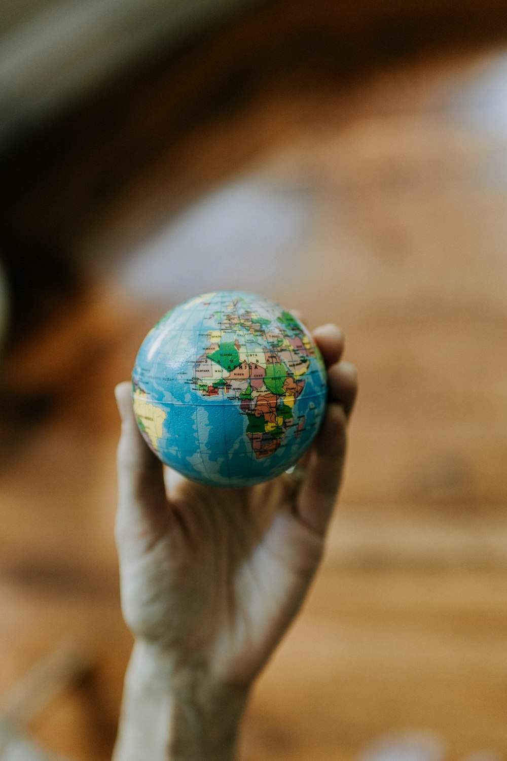 a person holding a small globe in their hand