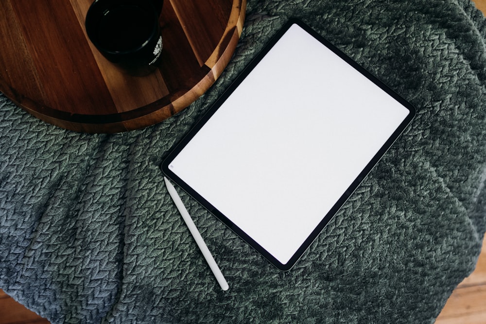 a notepad and pen on a blanket next to a cup of coffee