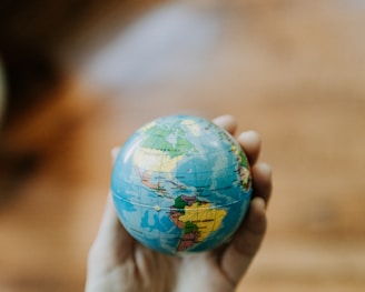 a person holding a small globe in their hand