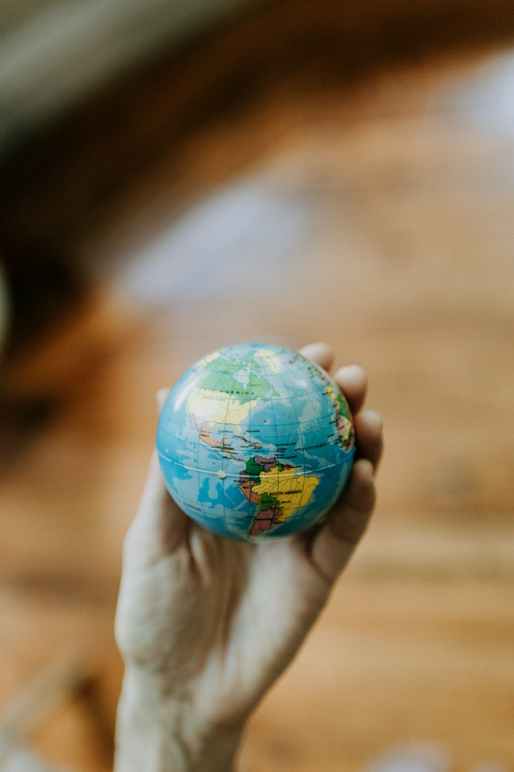 una persona sosteniendo un pequeño globo terráqueo en la mano