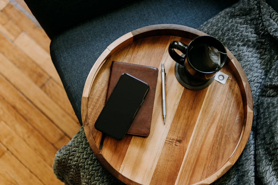 Solid walnut valet tray holding a notebook, pen, and cup on a tabletop