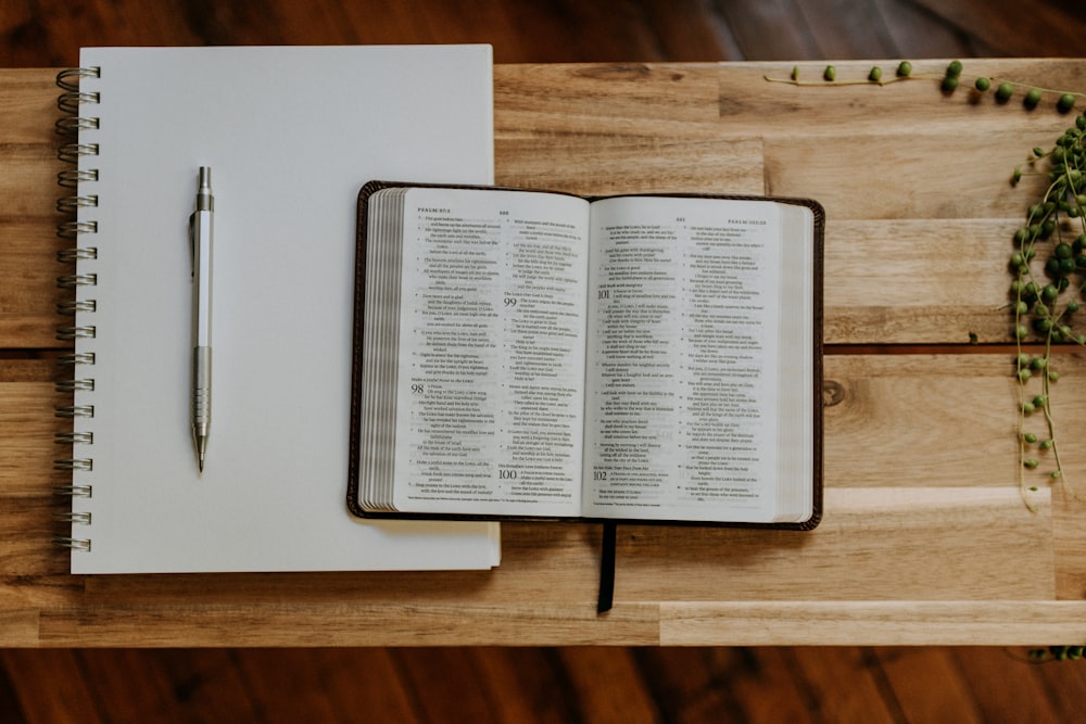 an open book with a pen on top of it