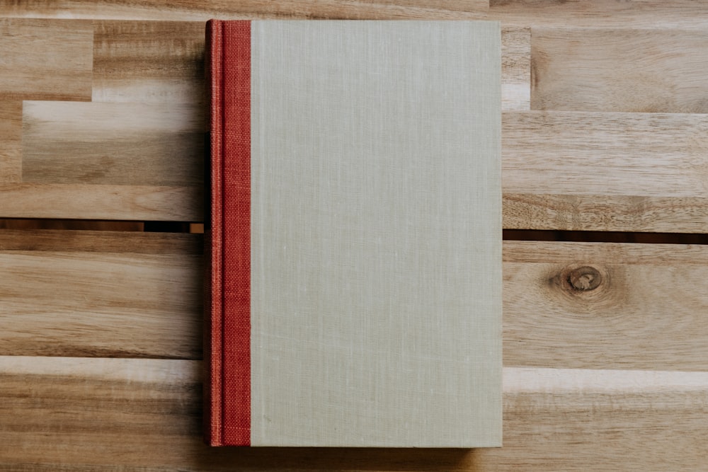 a red and white book sitting on top of a wooden floor