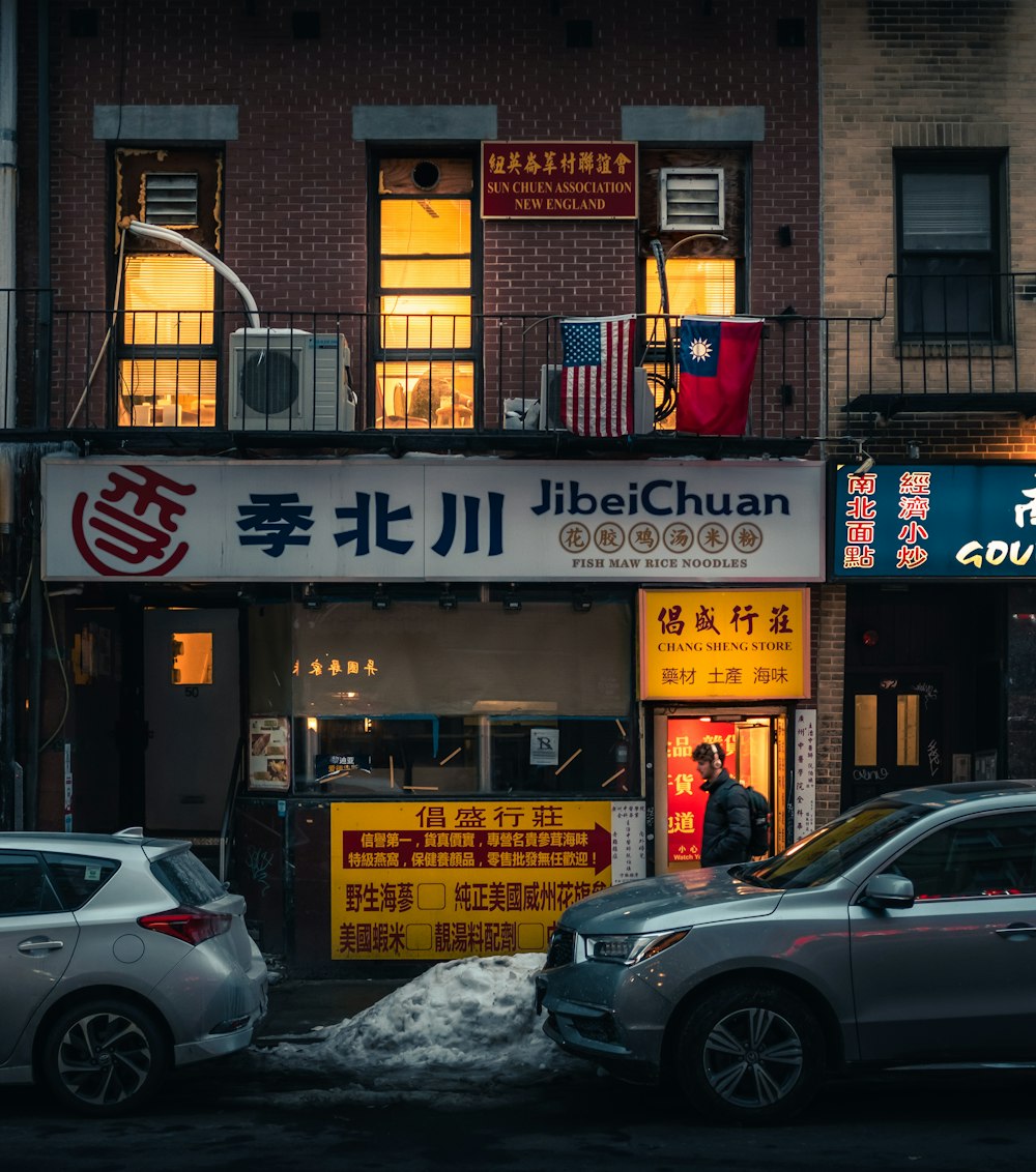 Un par de autos estacionados frente a un restaurante chino