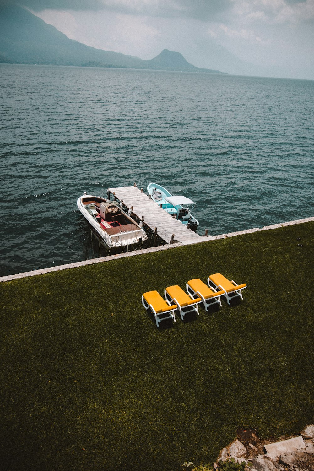 a row of lawn chairs sitting next to a dock