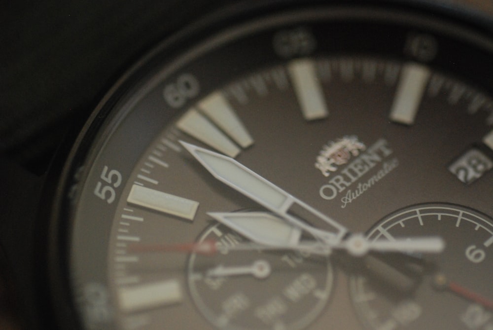 a close up of a watch with a black face