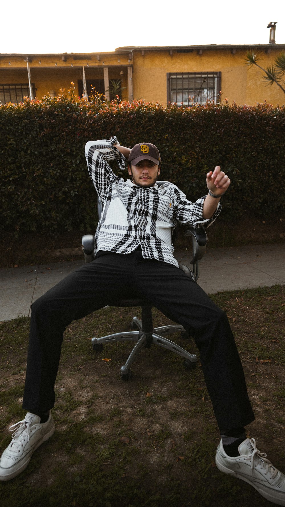 a man sitting in a chair in front of a house