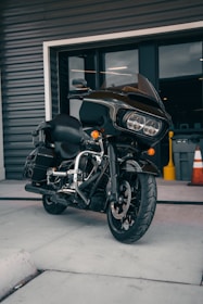 A motorcycle parked outside a modern office building ready for delivery.