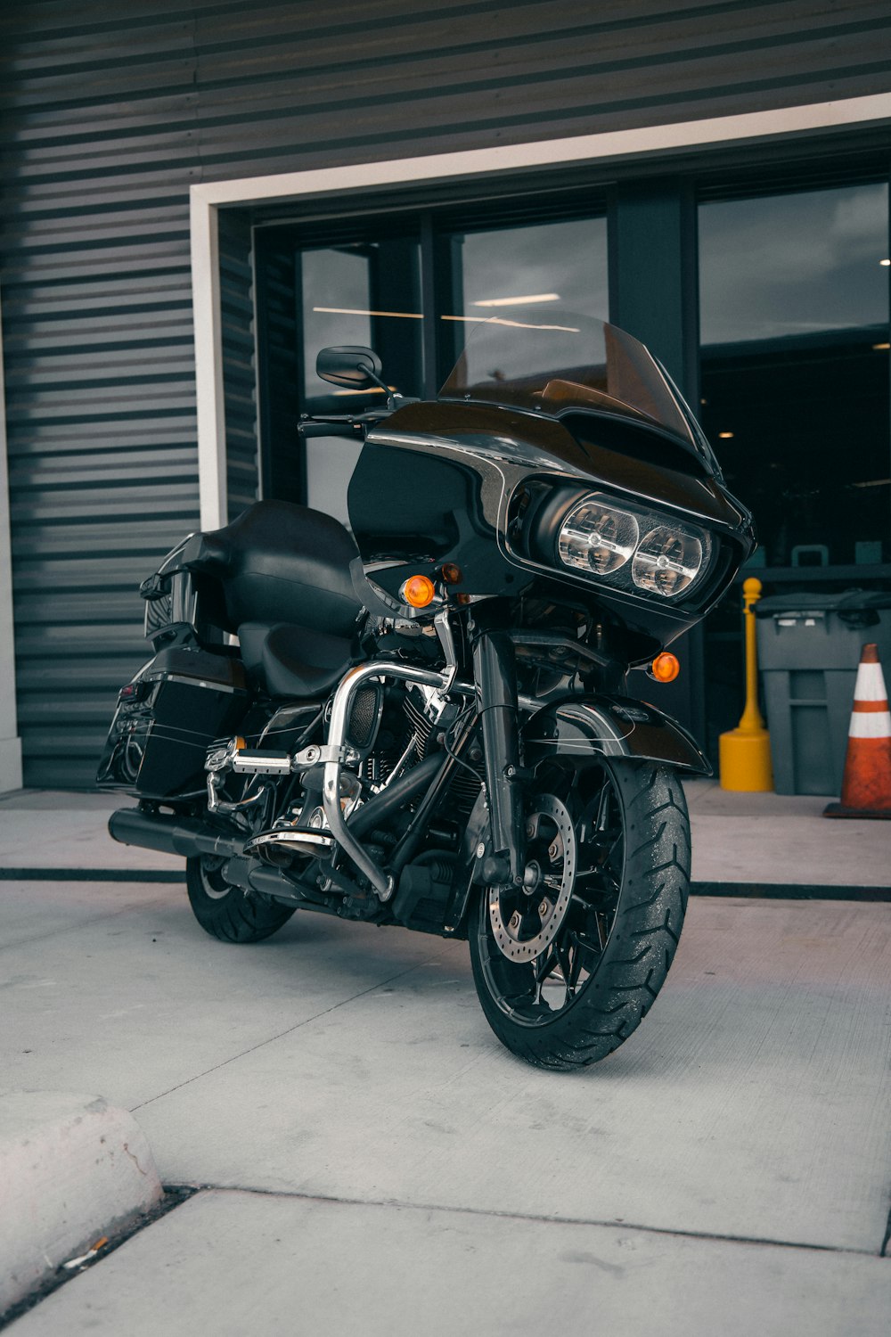 a black motorcycle parked in front of a garage