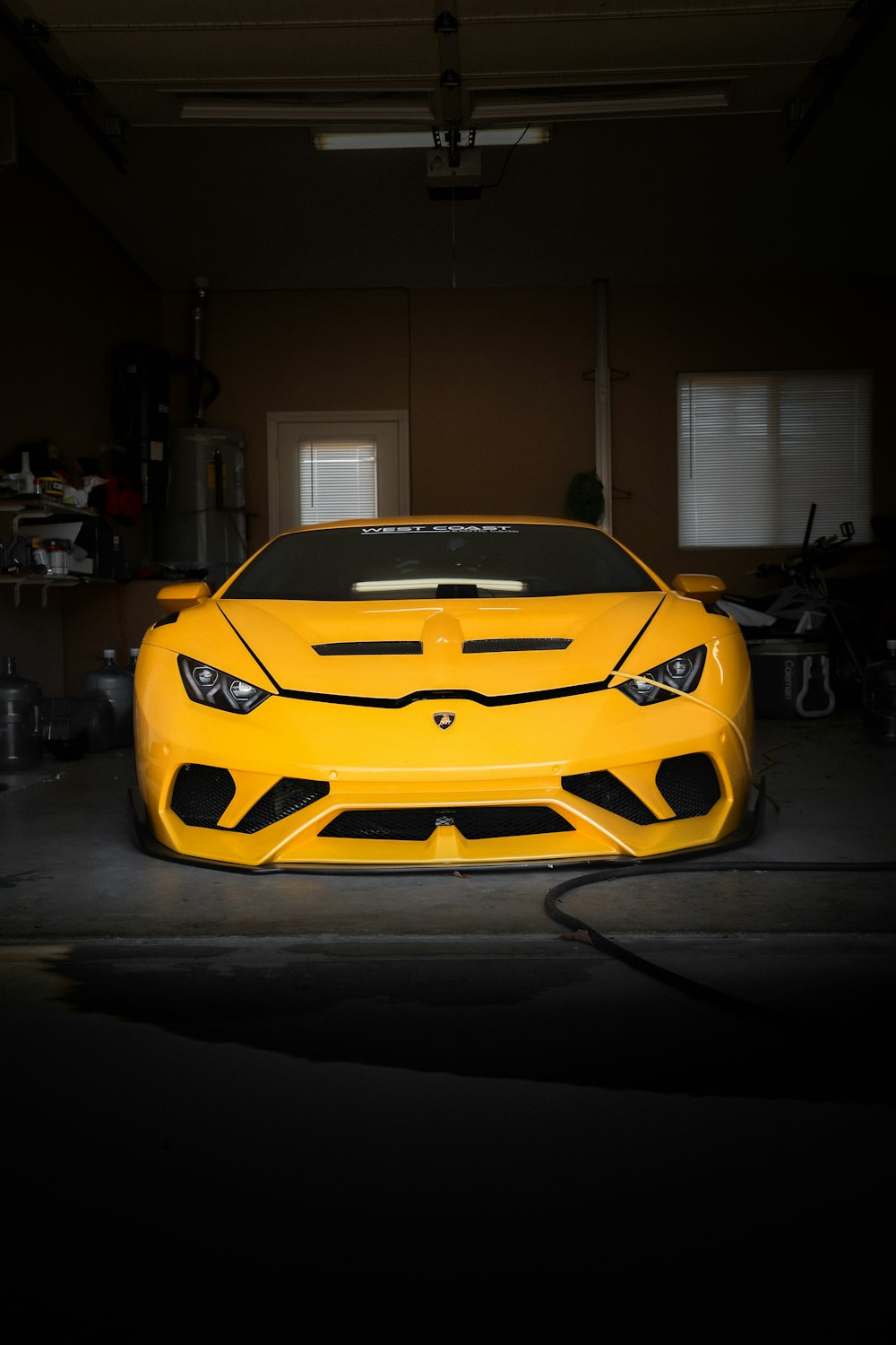 a yellow sports car parked in a garage