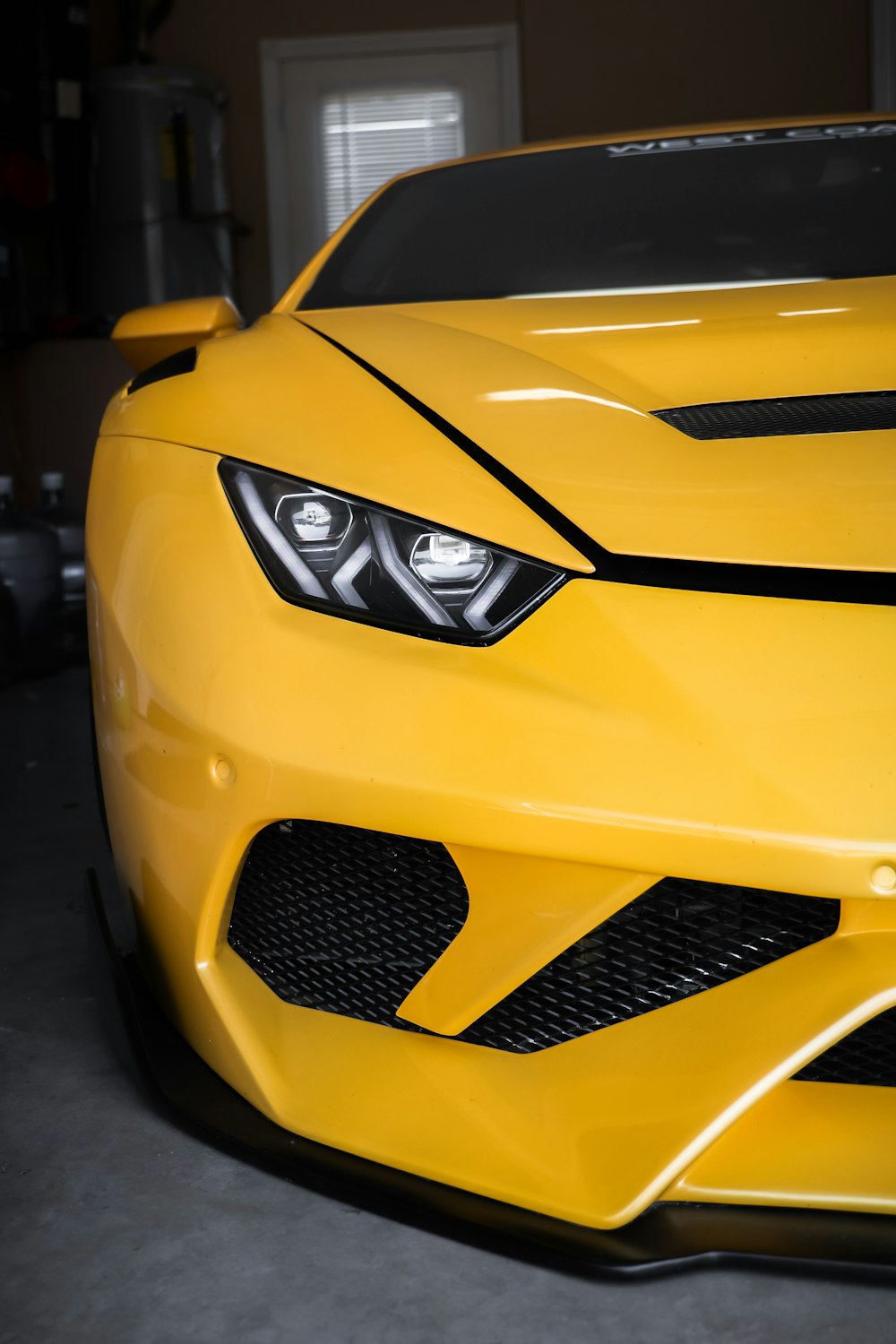 a yellow sports car parked in a garage