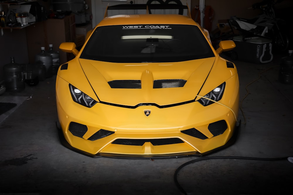 a yellow sports car parked in a garage