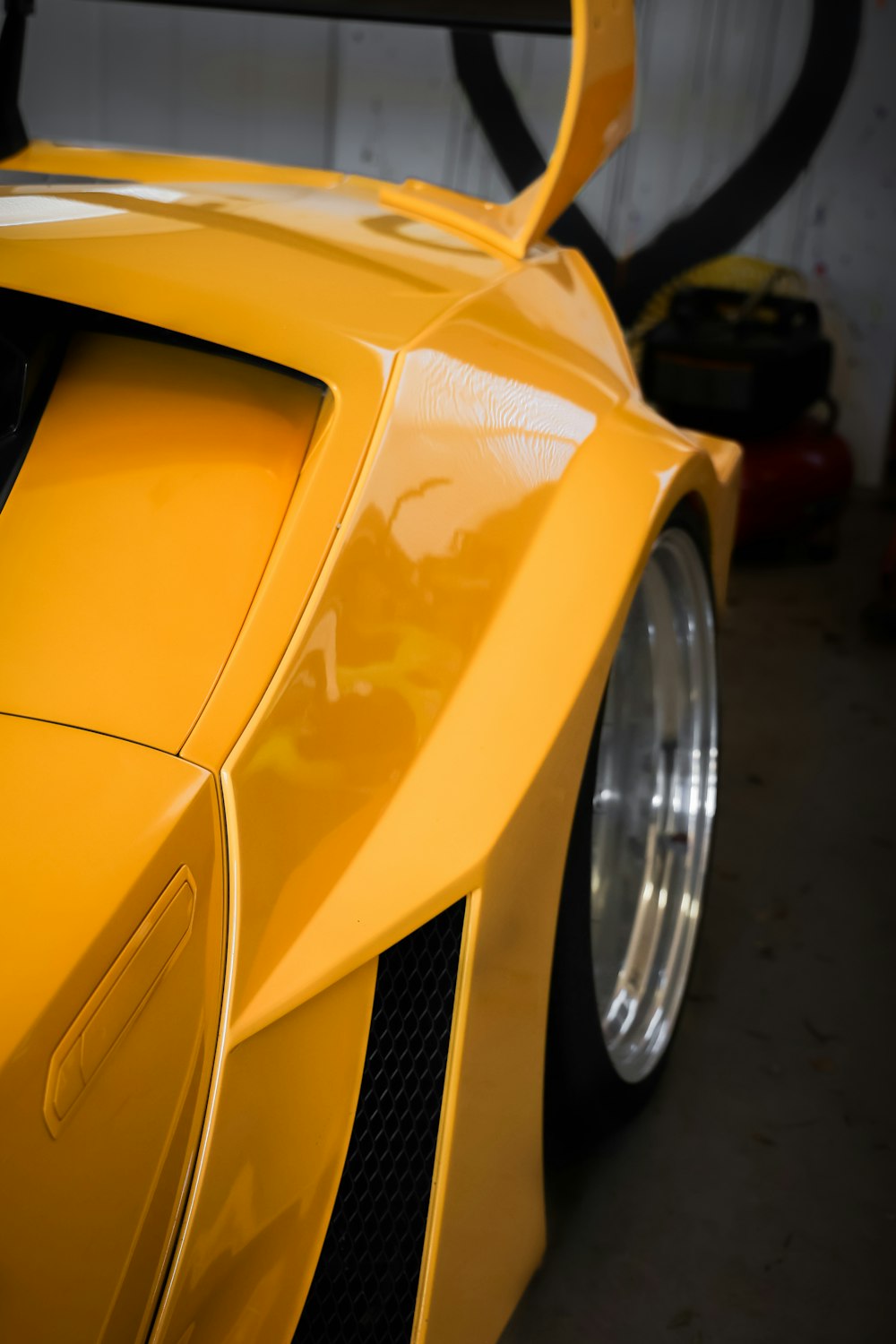 a yellow sports car parked in a garage