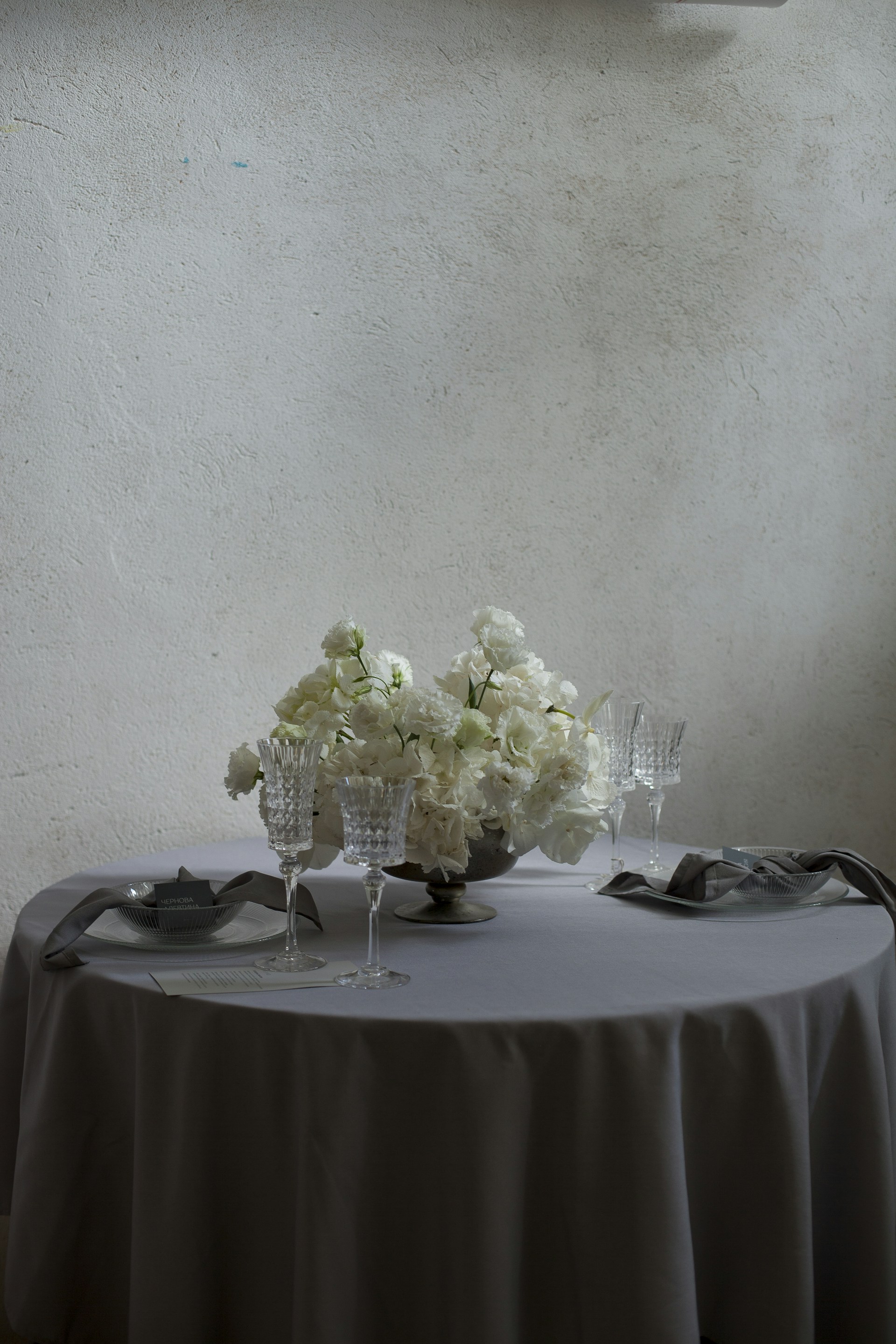 a table topped with a vase of white flowers