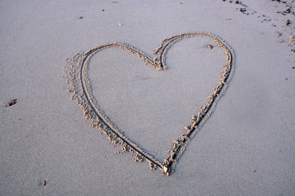 a heart drawn in the sand on a beach