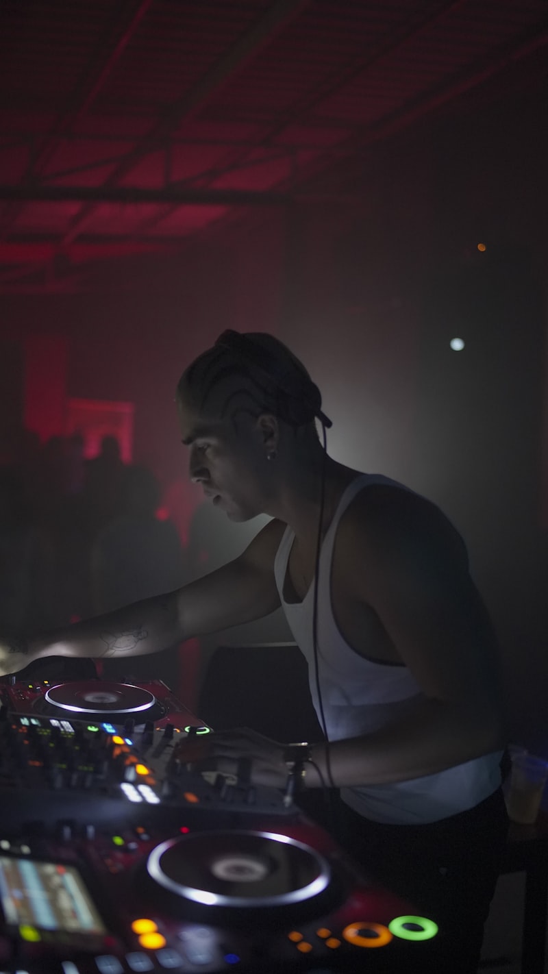 DJ em casa noturna com iluminação vermelha laser
