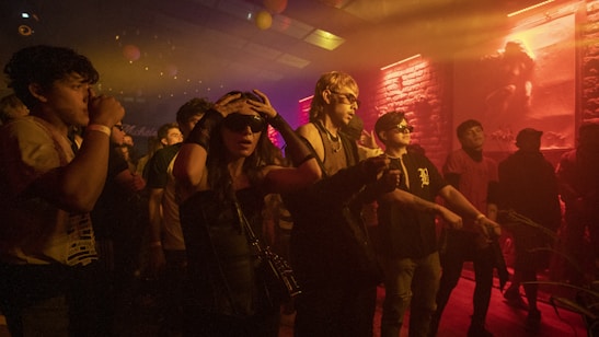 People enjoying a lively event with vibrant lighting and festive atmosphere