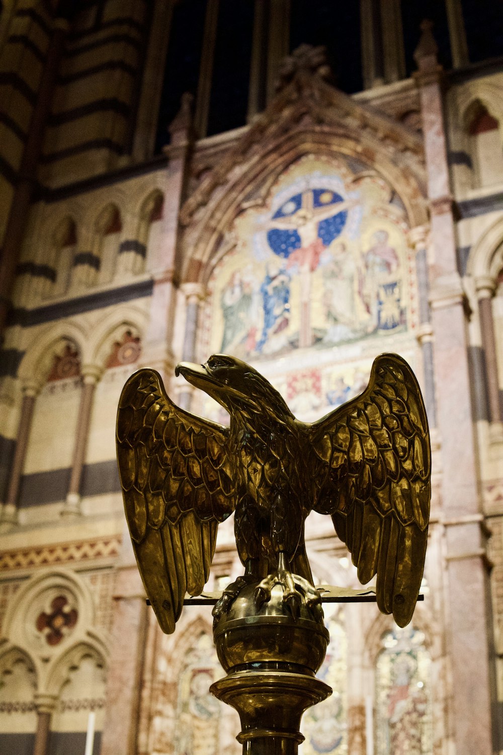 a statue of an eagle on a pedestal in front of a building