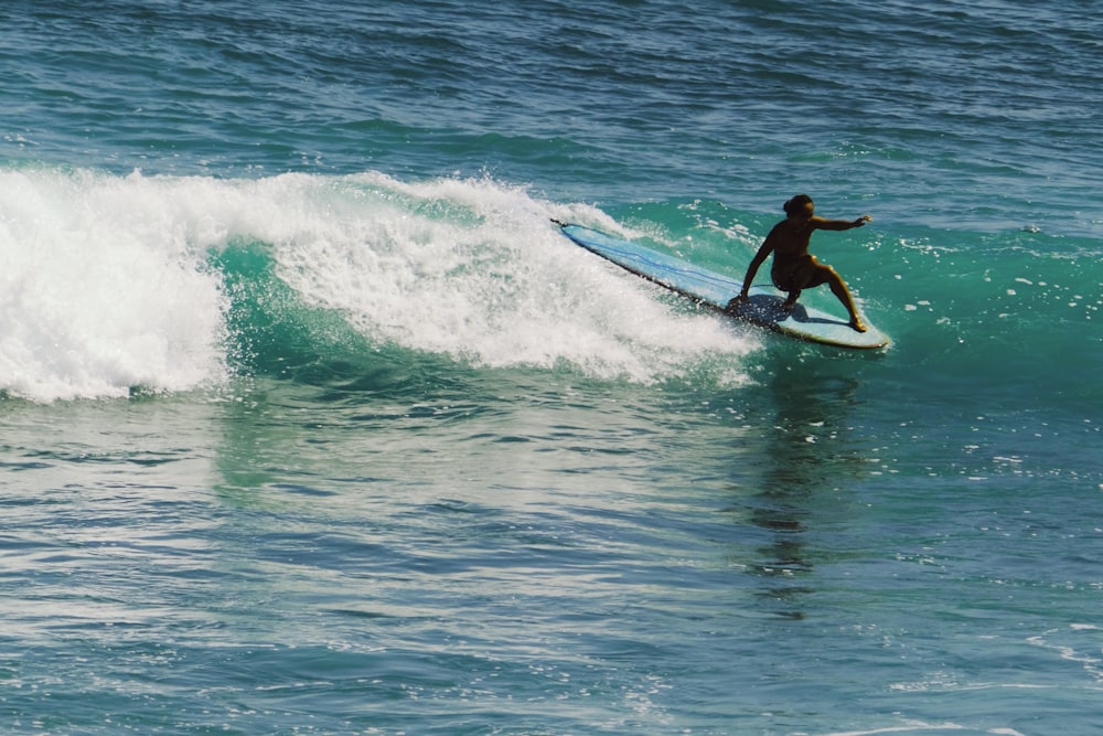 a man riding a wave on top of a surfboard