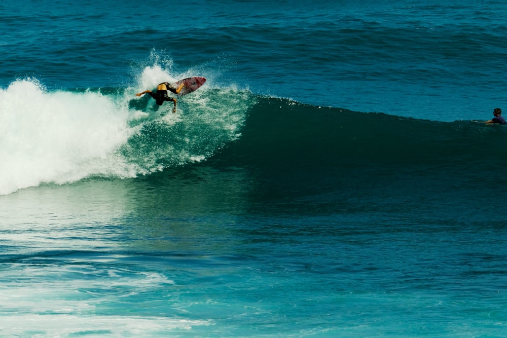 a man riding a wave on top of a surfboard