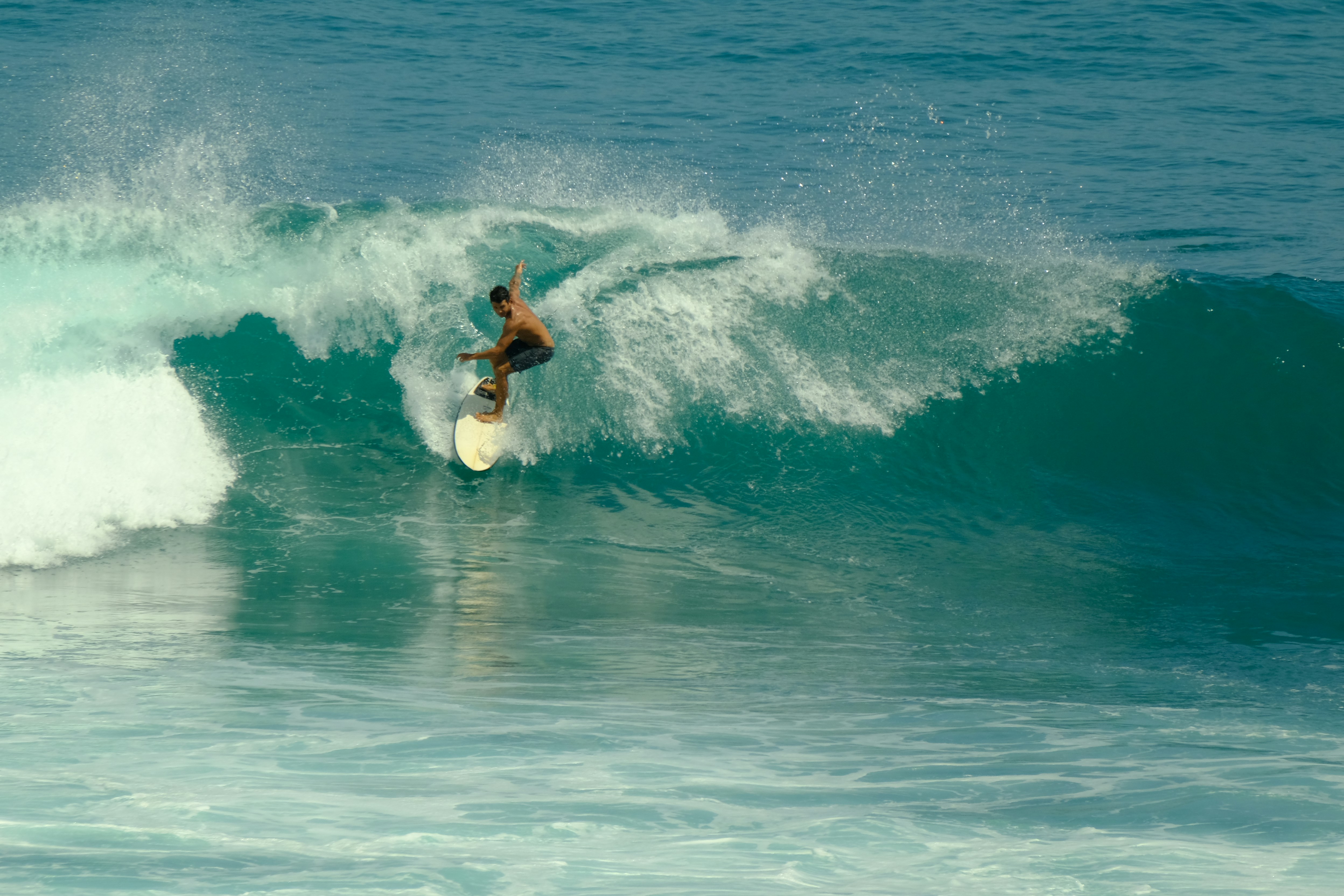 a man riding a wave on top of a surfboard