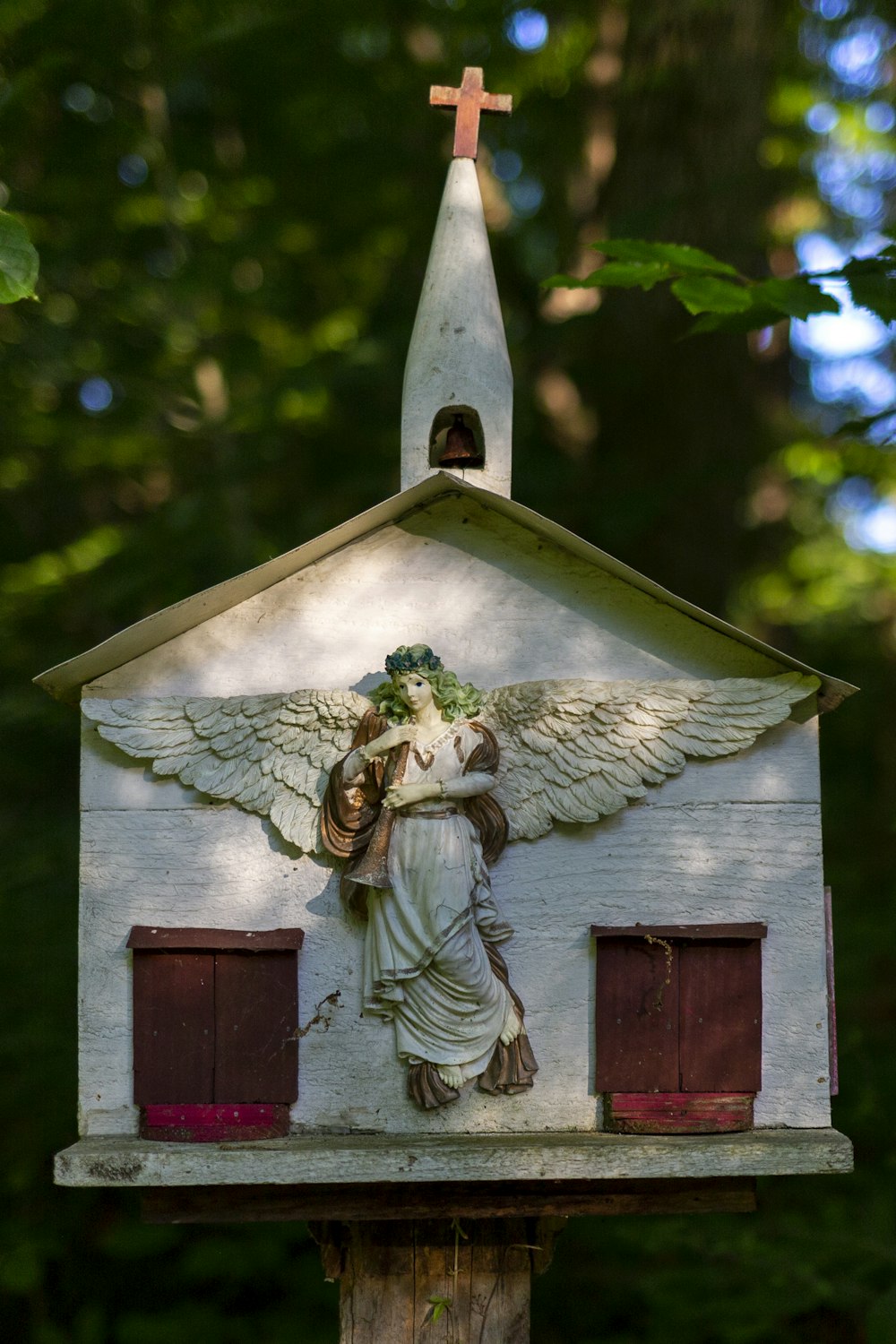 a white church with a statue of an angel on it