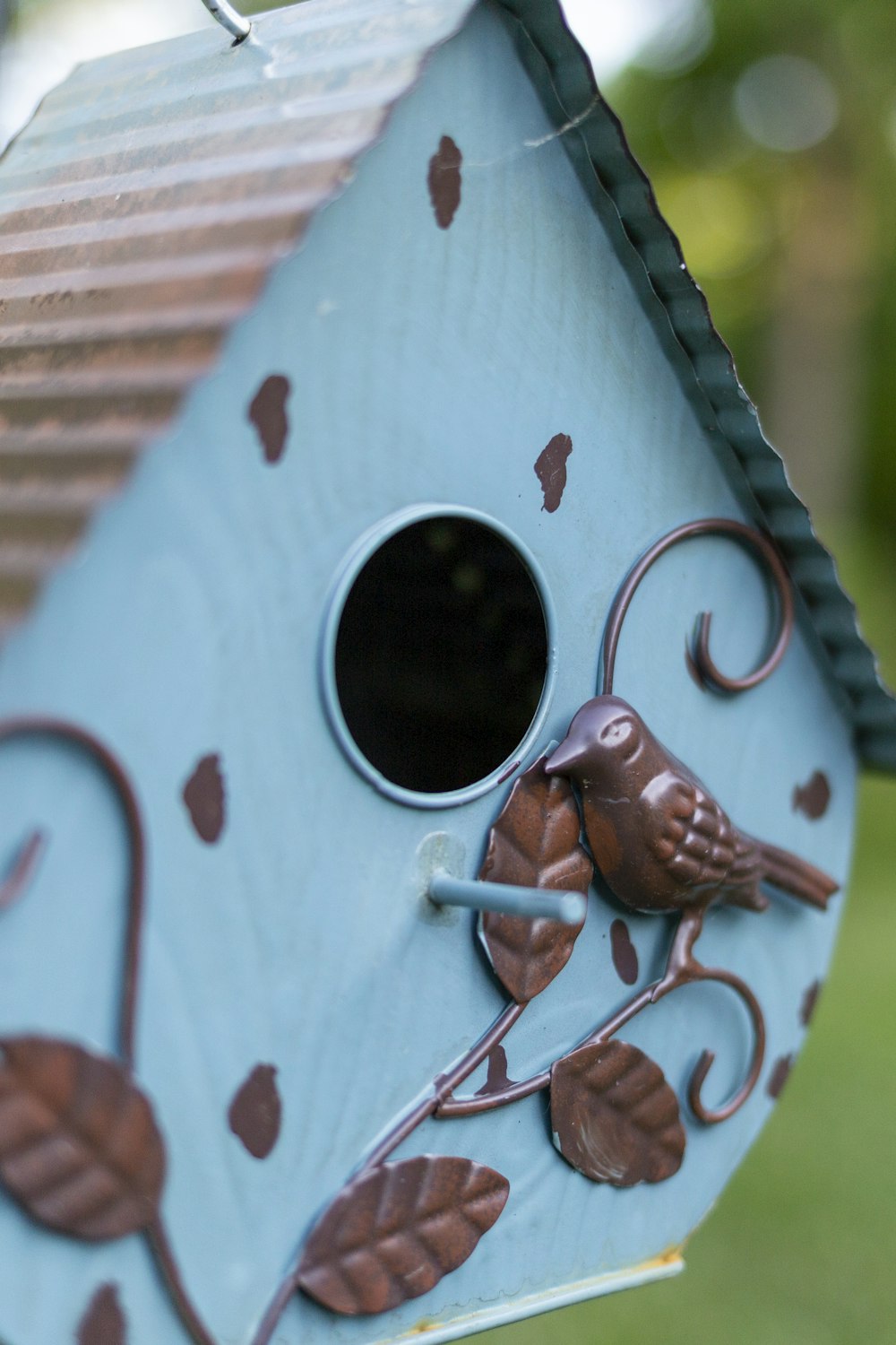 a blue birdhouse with a bird on it's side