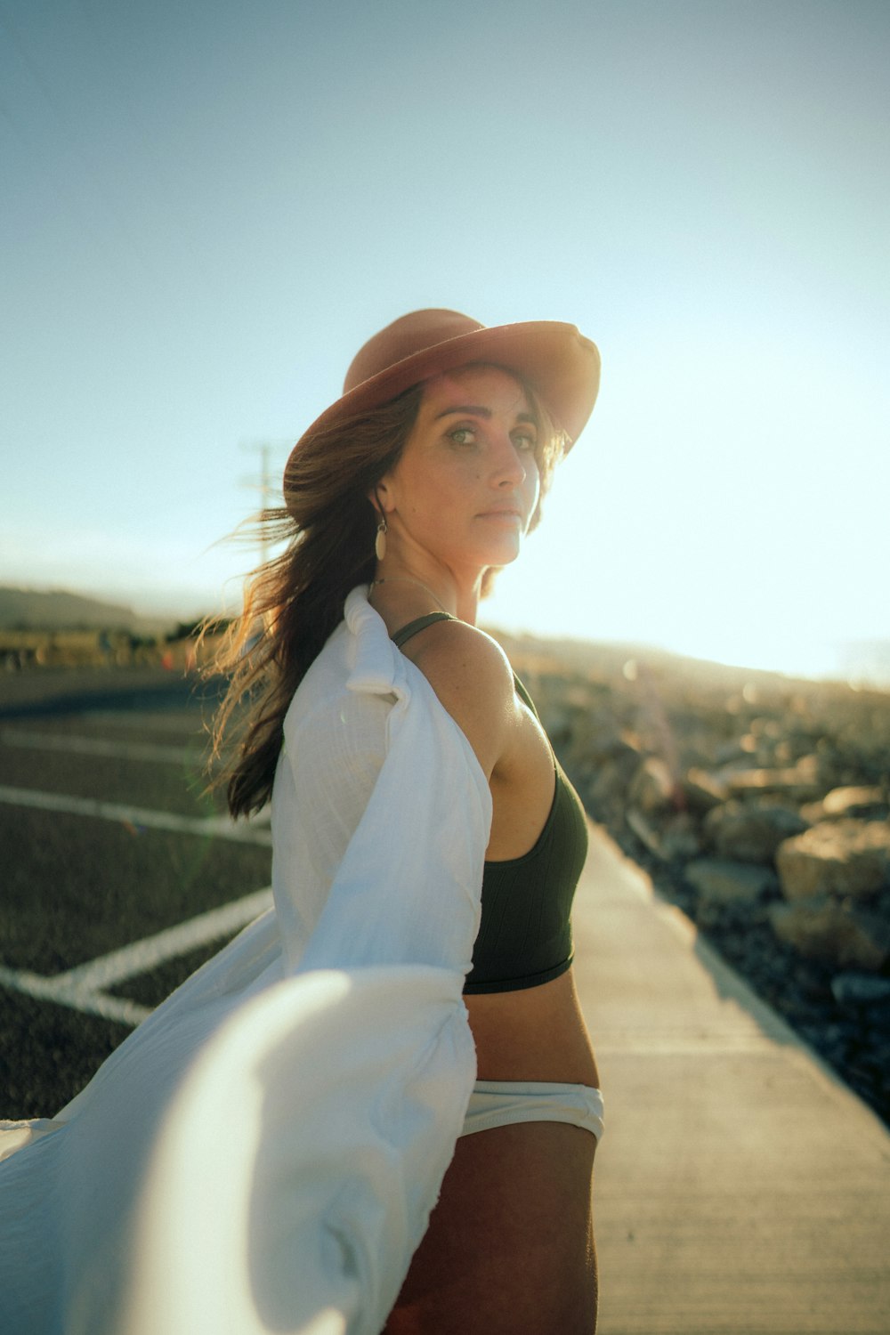 a woman wearing a hat and a white scarf